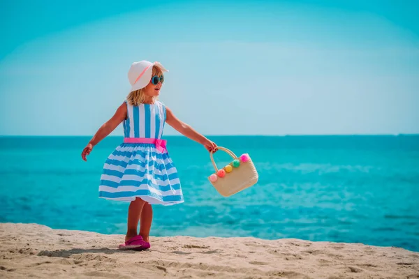 Tropikal sahilde çantası olan sevimli küçük bir kız. — Stok fotoğraf