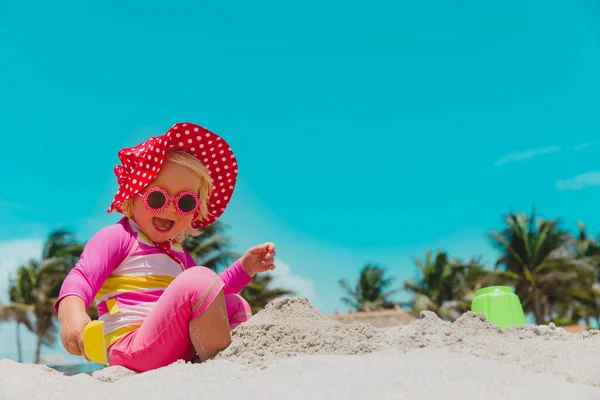 Schattig klein meisje spelen met zand op het strand — Stockfoto