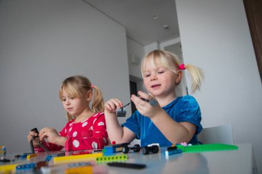 Çocuklar evde plastik bloklarla oynuyorlar, çocuklar için öğrenim aktiviteleri yapıyorlar.