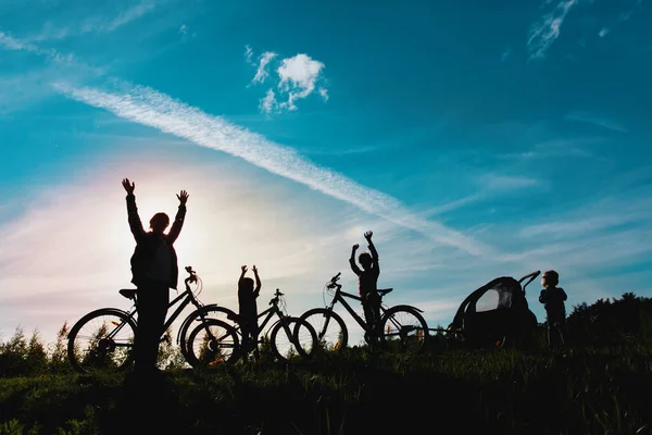 Щаслива сім'я на велосипедах на природі заходу сонця, тато і діти фізичні вправи на природі — стокове фото