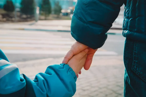 Far och barn håller hand när de korsar gatan utomhus — Stockfoto