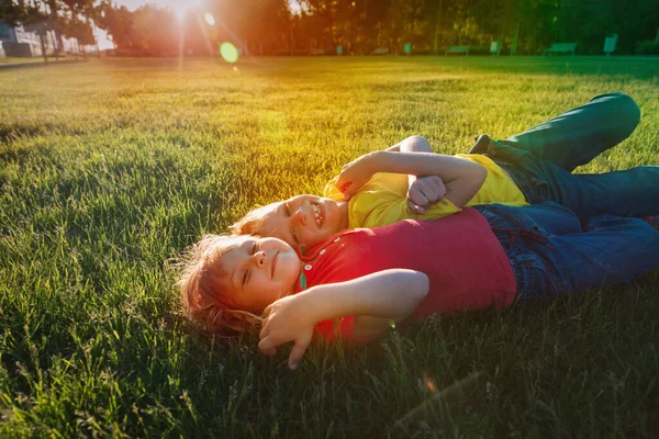 Menino feliz e menina se divertir ao pôr do sol, as crianças gostam da natureza — Fotografia de Stock