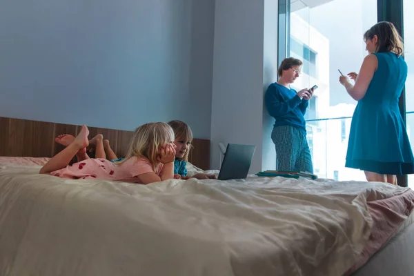 Familie zu Hause, Eltern mit Mobiltelefonen und Kinder, die drinnen Computer anschauen — Stockfoto