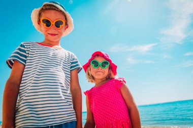 Mutlu küçük oğlan ve kız kumsalın tadını çıkarın.