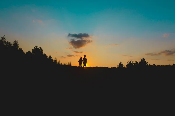 Silhouette de garçon et fille heureux courir au coucher du soleil — Photo