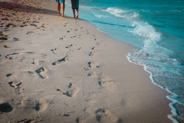 Madre e hijo caminando en la playa dejando huella en la arena —  Fotos de Stock
