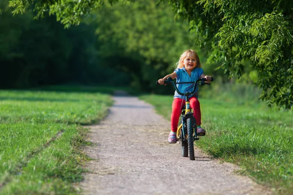 Aranyos boldog kislány lovaglás kerékpár a természetben — Stock Fotó