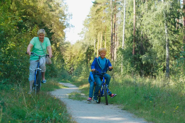 Grand-mère aînée active avec des enfants en vélo dans la nature — Photo