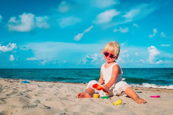 Bonito menina jogar com areia na praia — Fotografia de Stock