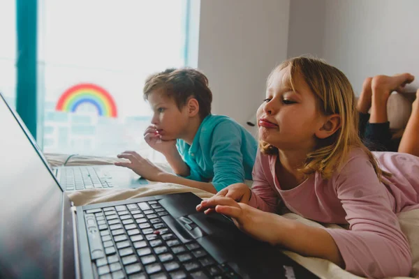 Kinder gelangweilt zu Hause bleiben, Jungen und Mädchen mit Computer drinnen — Stockfoto