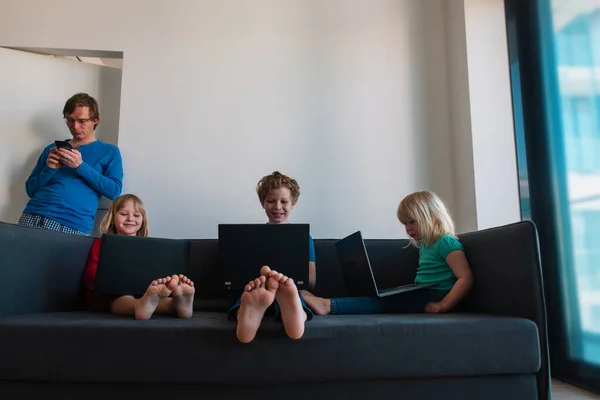 Familia quedarse en casa, padre trabajando a distancia mientras los niños en el aprendizaje a distancia con computadoras —  Fotos de Stock