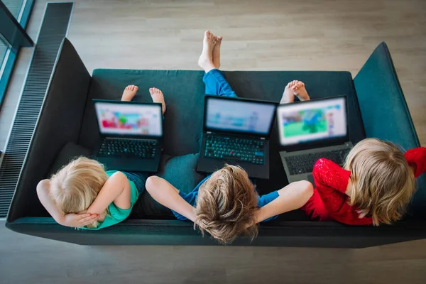 Niños mirando a la computadora portátil mientras se quedan en casa, familia en cuarentena —  Fotos de Stock