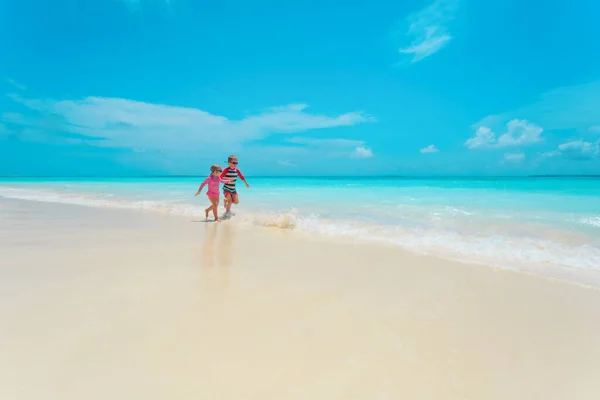 Felice bambina e ragazzo correre e divertirsi sulla spiaggia — Foto Stock