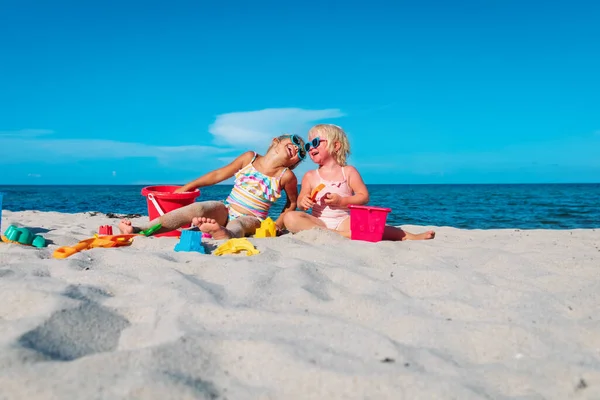 Schattig gelukkig kleine meisjes spelen met zand op het strand — Stockfoto