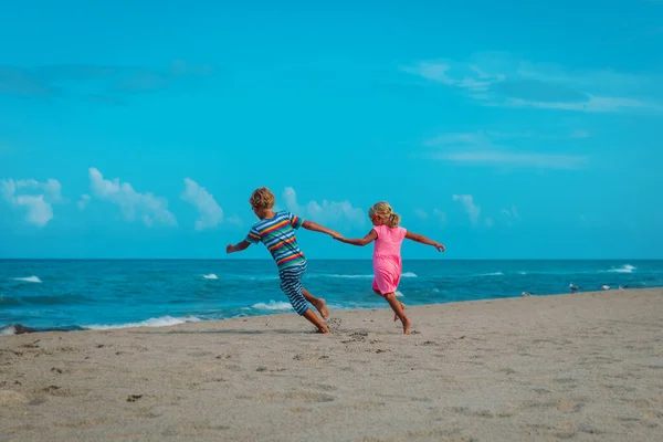 Petit garçon et fille courant sur la plage, les enfants profitent des vacances à la mer — Photo