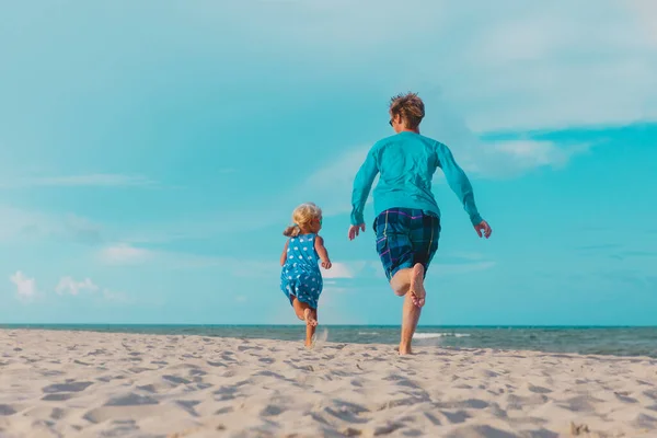 Mutlu baba ve küçük kız sahilde oynuyorlar. — Stok fotoğraf