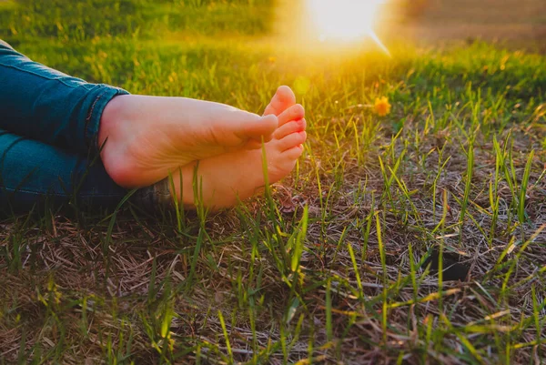 Baby bar fot på gräs på sommaren solnedgång natur — Stockfoto