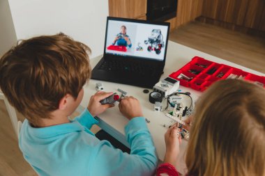 Çocuklar robotu çevrimiçi robotik teknoloji dersiyle yapıyorlar.