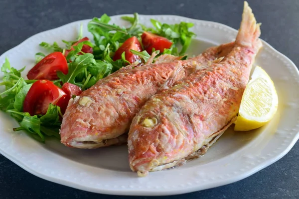 Grilled red mullet in a plate with herbs, tomato and lemon. Healthy food. Mediterannean lifestyle — Stock Photo, Image