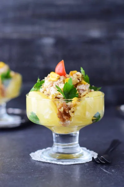 Salat mit Hühnerfilet, Ananas, Pilzen, Walnüssen in einer Glasschale auf einem grauen, abstrakten Hintergrund. Konzept für gesunde Ernährung. Traditionelles russisches Essen — Stockfoto