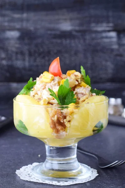 Salat mit Hühnerfilet, Ananas, Pilzen, Walnüssen in einer Glasschale auf grauem, abstraktem Hintergrund. Konzept für gesunde Ernährung. Traditionelles russisches Essen — Stockfoto
