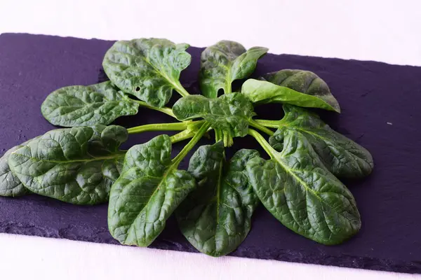 Fresh spinach on a dark stone . Healthy eating concept. Dieting. — Stock Photo, Image