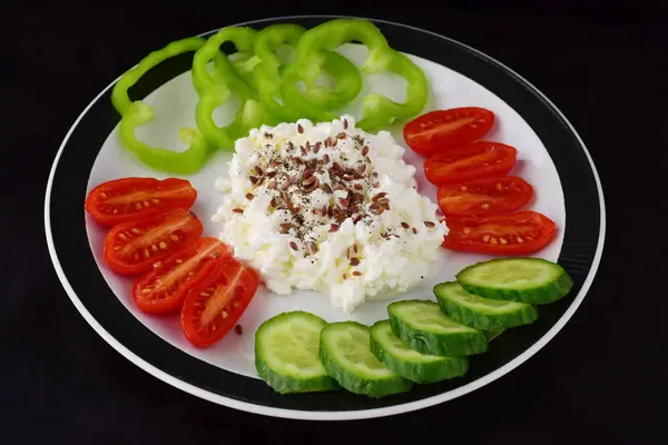 Petit déjeuner facile avec paprika, tomate, concombre avec fromage cottage et graines de lin sur une assiette sur un fond sombre concept de saine alimentation. Aliments sains . — Photo