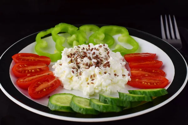 Petit déjeuner facile avec paprika, tomate, concombre avec fromage cottage et graines de lin sur une assiette sur un fond sombre concept de saine alimentation. Aliments sains . — Photo