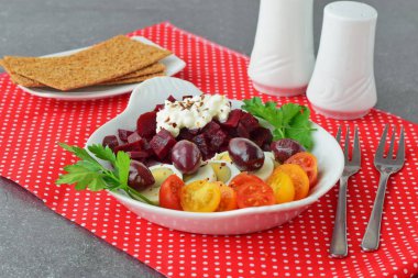 Kolay Kahvaltı: beetroots, kiraz domates, yumurta, peynir ve kraker kırmızı Tekstil arka plan üzerinde beyaz bir tabak içinde. Sağlıklı gıda kavramı