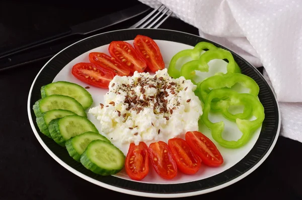 Petit déjeuner facile avec paprika, tomate, concombre avec fromage cottage et graines de lin sur une assiette sur un fond sombre concept de saine alimentation. Aliments sains . — Photo