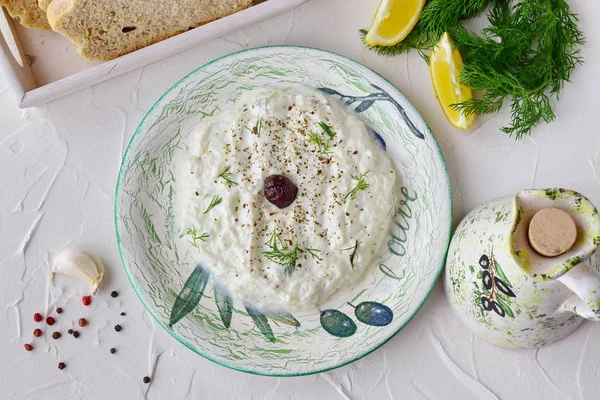 Sauce traditionnelle grecque maison tzatziki avec concombre, ail, yaourt et citron dans un bol et un bocal avec de l'huile d'olive sur un fond abstrait. Concept de saine alimentation. Style de vie méditerranéen . — Photo