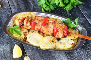 Ahşap arka plan üzerinde metal bir plaka üzerinde kızarmış patates tatlı kırmızı biber ile tavuk fileto ızgara. Sağlıklı beslenme kavramı.