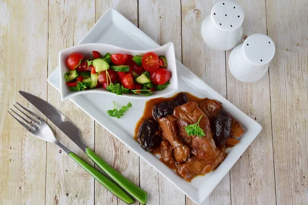 Мясо телятины, приготовленное из копченого чернослива на белой тарелке со свежим овощным салатом и вареным рисом. Концепция здорового питания . — стоковое фото