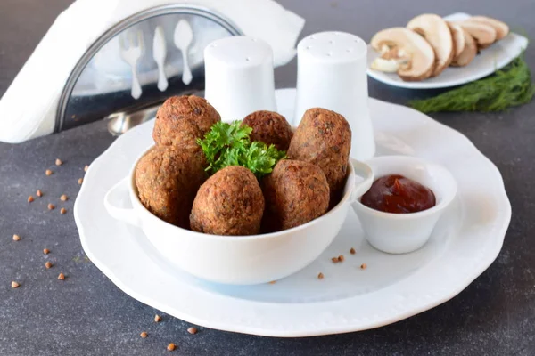 Bolas com trigo sarraceno e cogumelos em uma tigela branca em um fundo abstrato cinza. A fazer dieta. Comida de jejum. conceito de alimentação saudável . — Fotografia de Stock