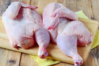 Ahşap kesme tahtası üzerinde çiğ tavuk iki yarısı. Adım adım yemek. Sağlıklı beslenme kavramı.