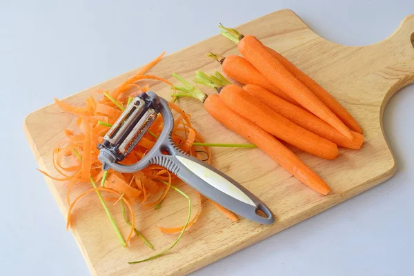 Шаг за шагом готовка. Морковь на деревянной доске для резки на сером фоне . — стоковое фото