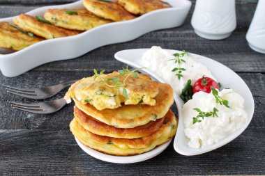 Taze yeşil soğan ve koyu ahşap arka plan üzerinde taze Yunan Yoğurtlu beyaz tabakta haşlanmış yumurta adet börek. Sağlıklı kahvaltı. Sağlıklı beslenme kavramı.