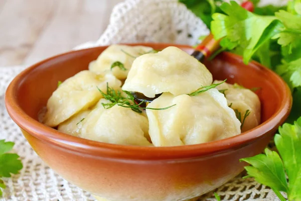 Traditional russian pelmeni with minced meat and onions filling in a brown ceramic bowl. — Stock Photo, Image