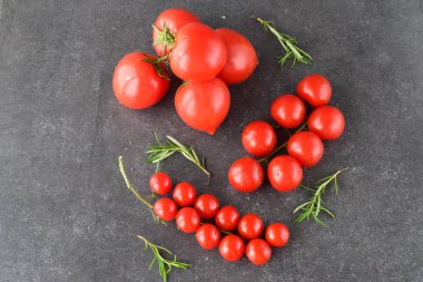 Domates biberiye ve deniz ile dalları üzerinde farklı türde bir koyu gri arka plan üzerinde tuz. Metin için yer. Sağlıklı beslenme kavramı.