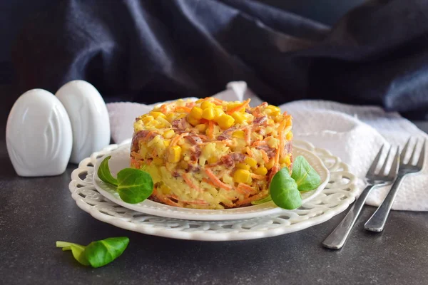 Salat mit geräucherter Wurst, Mais, Käse, frischen Karotten, Ei, Knoblauch und Joghurt auf einem weißen Teller auf abstraktem Hintergrund. — Stockfoto