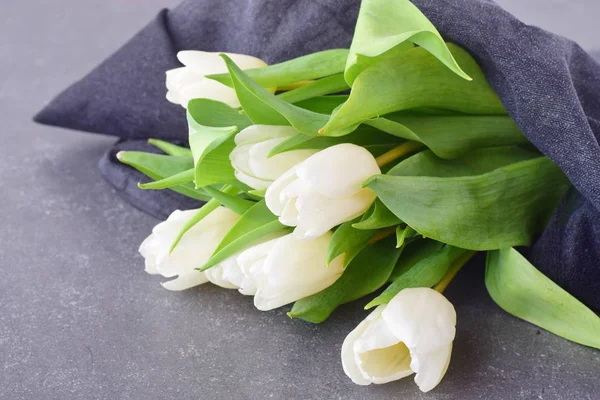 Ramo de tulipanes multicolores sobre un paño gris. Flores de primavera. Romance. — Foto de Stock