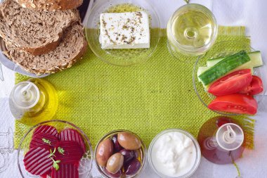 Yeşil kumaş arka plan ile bir metin için yer. Geleneksel Akdeniz cinayet sebebi - beyaz peynir, cacık, zeytin, sarımsak, zeytinyağı, domates, kırmızı pancar, domates, beyaz SEK şarap kavanoz. Sağlıklı gıda.