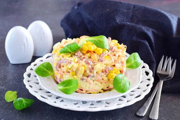 Salat mit geräucherter Wurst, Mais, Käse, frischen Karotten, Ei, Knoblauch und Joghurt auf einem weißen Teller auf abstraktem Hintergrund. — Stockfoto