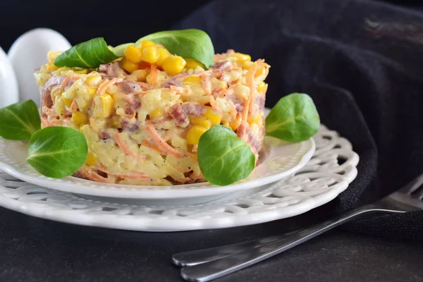 Salat mit geräucherter Wurst, Mais, Käse, frischen Karotten, Ei, Knoblauch und Joghurt auf einem weißen Teller auf abstraktem Hintergrund. — Stockfoto