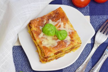 Ev yapımı lazanya kıyma, domates, peynir beyaz tabakta ile dilim. Sağlıklı beslenme kavramı.