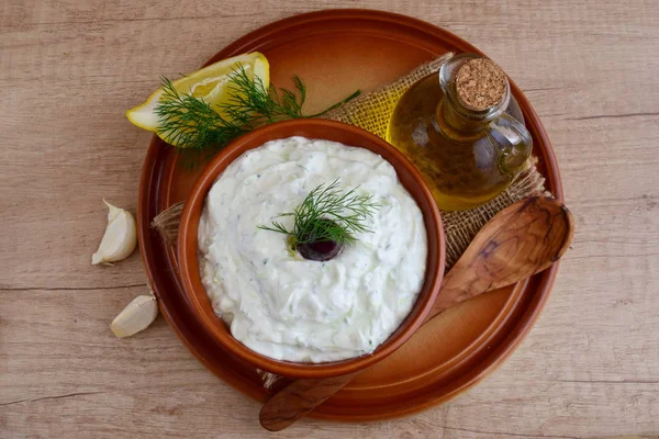 Tzatziki - salsa de yogur con pepino, eneldo, aceite de oliva, limón y ajo en un tazón tradicional, cocina griega tradicional.Vista superior — Foto de Stock