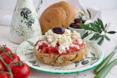 Geleneksel bir tabakta geleneksel Yunan aperatifi seramik zeytin yağı kavanozu, çavdar ekmeği, zeytin ve zeytin dalı. Sağlıklı beslenme konsepti. Akdeniz yaşam tarzı