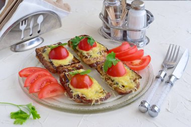 Patlıcan, peynir ve domates bir cam tabakta tost.