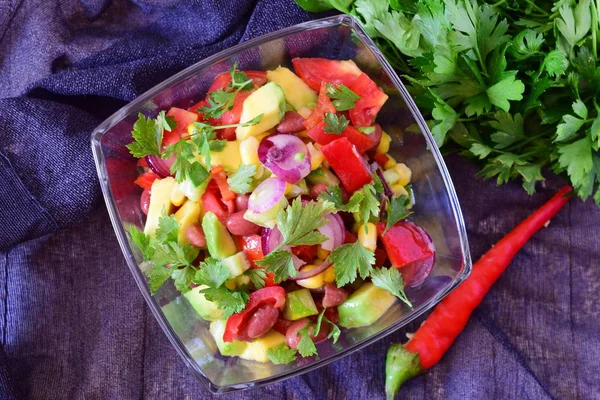 Мексиканский салат с помидорами, авокадо, красными бобами, кукурузой, паприкой, красным луком, лимоном, чили, оливковым маслом, петрушкой — стоковое фото