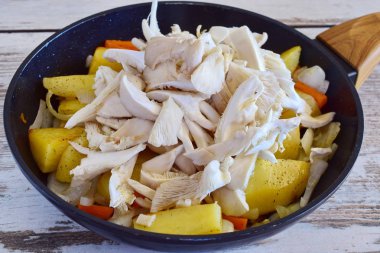 Kesme istiridye mantar bir tavada kızarmış patates.